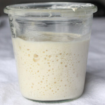 glass jar of bubbling sourdough starter