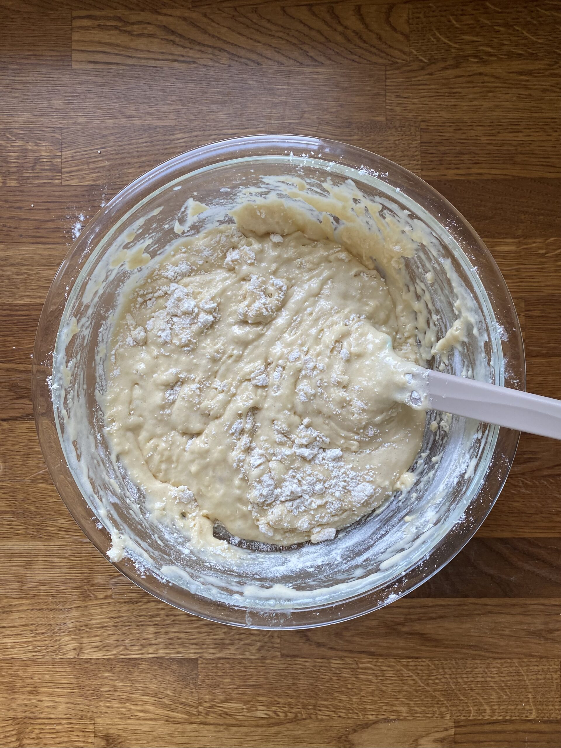 Mixing flour into muffin batter until just a few dry spots remain.
