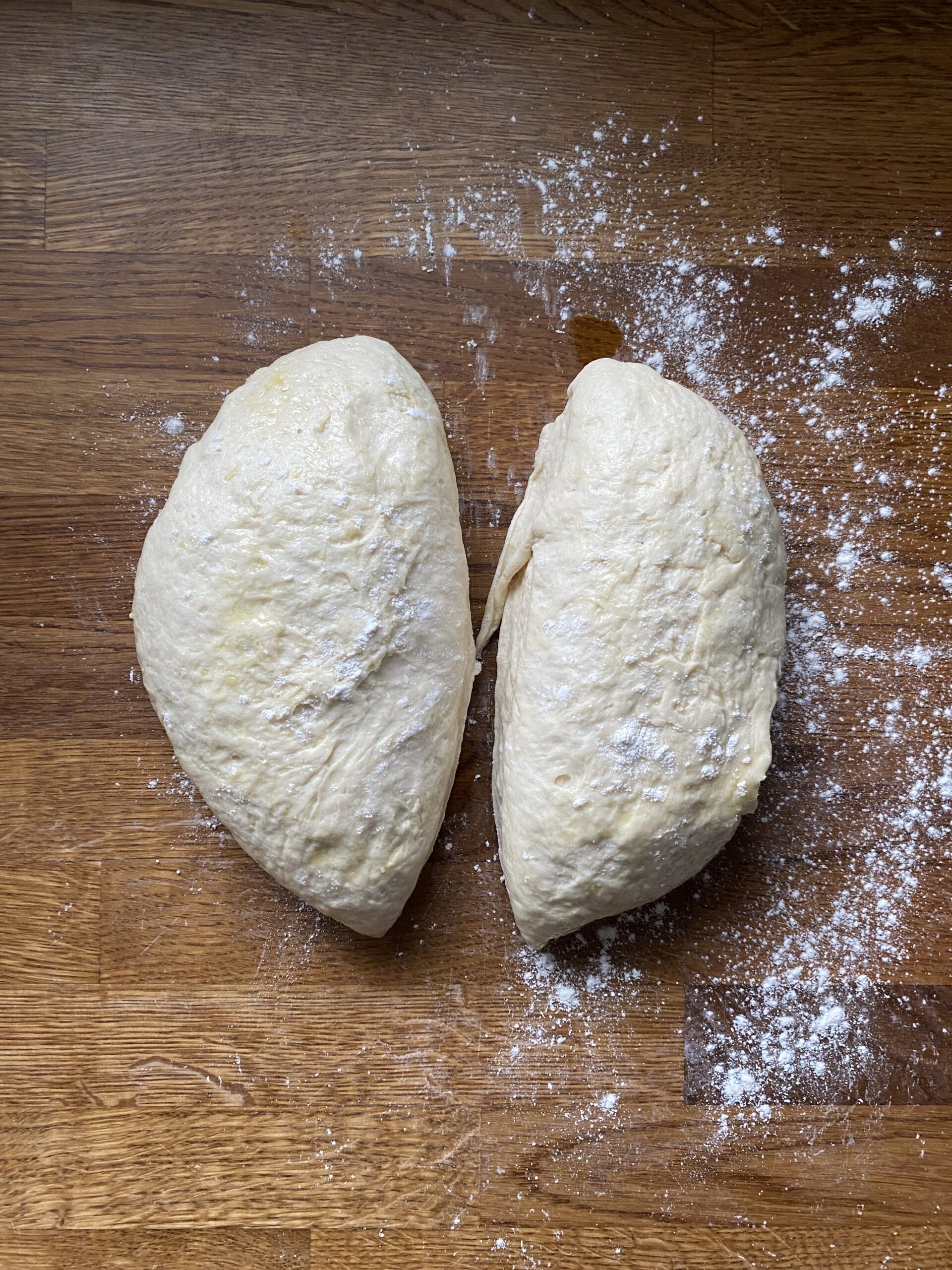 Flatbread dough split in half on work surface to make two flatbreads.
