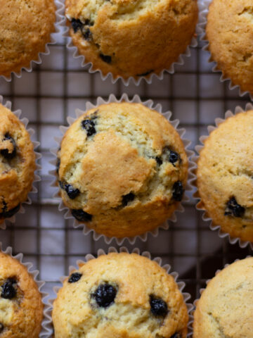 Close up of sourdough discard blueberry muffin cooling on wire rack.