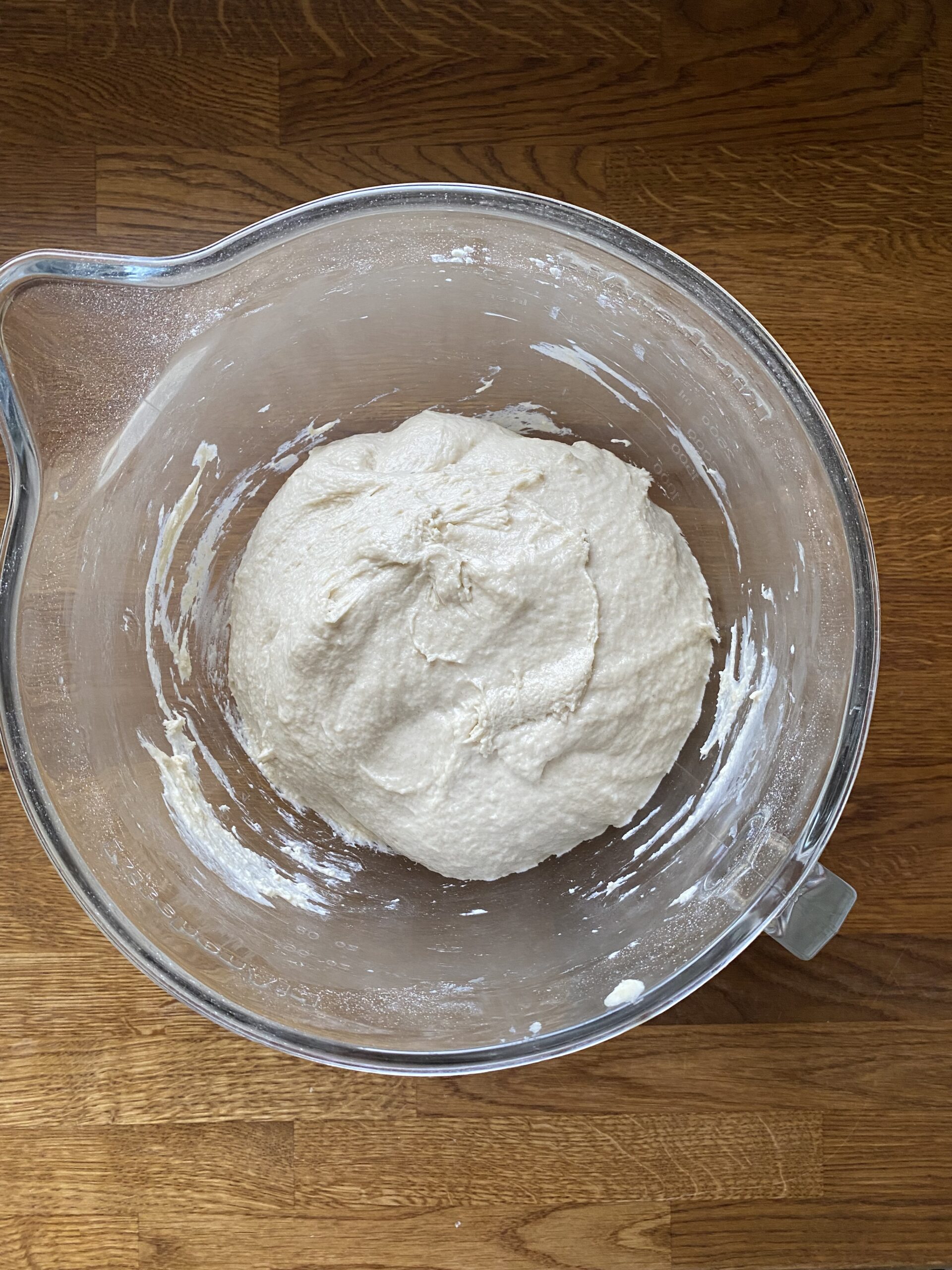 Sourdough discard hoagie roll dough in a glass bowl after kneading.