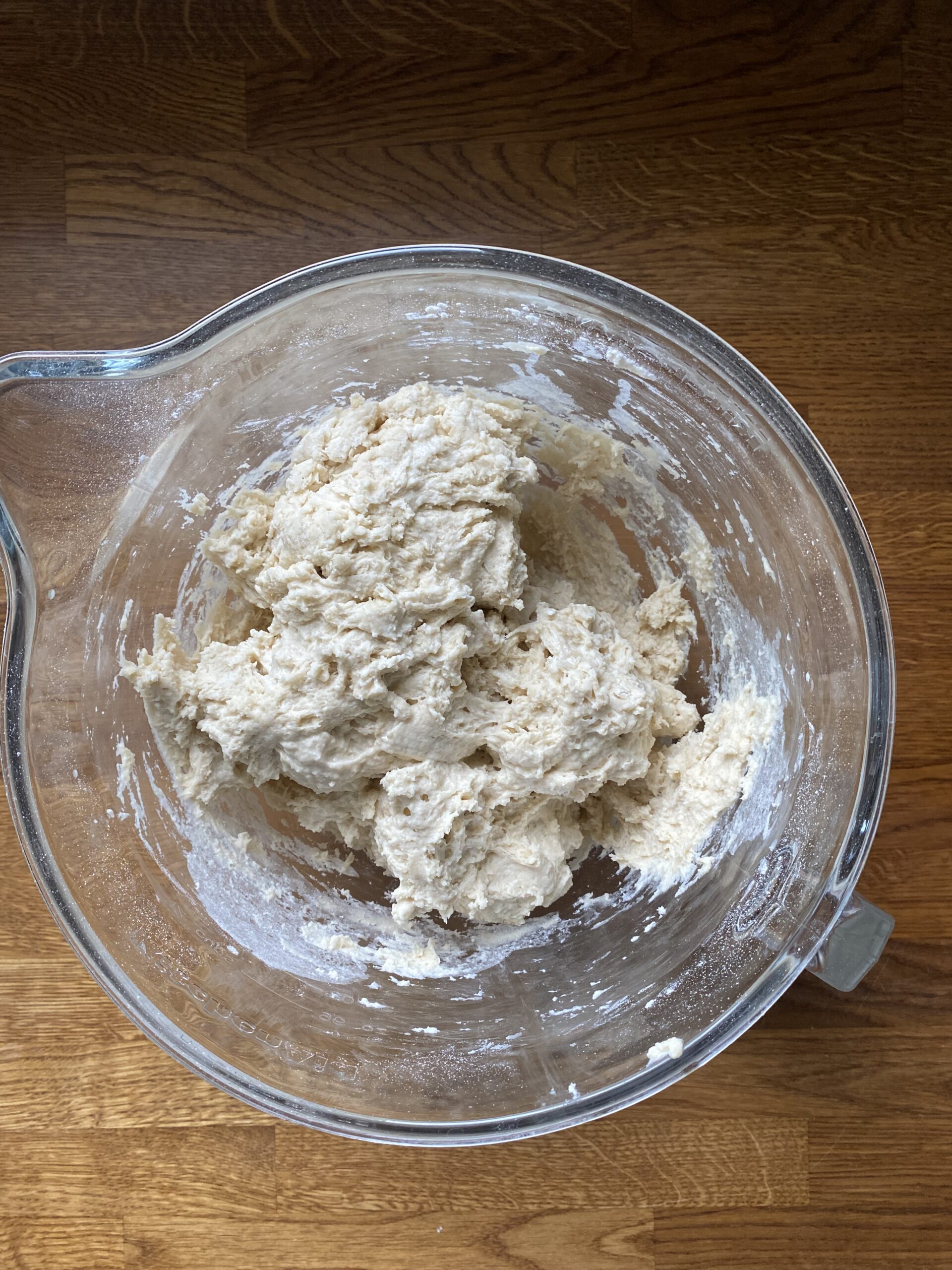 Sourdough discard hoagie roll dough mixed in a glass bowl.