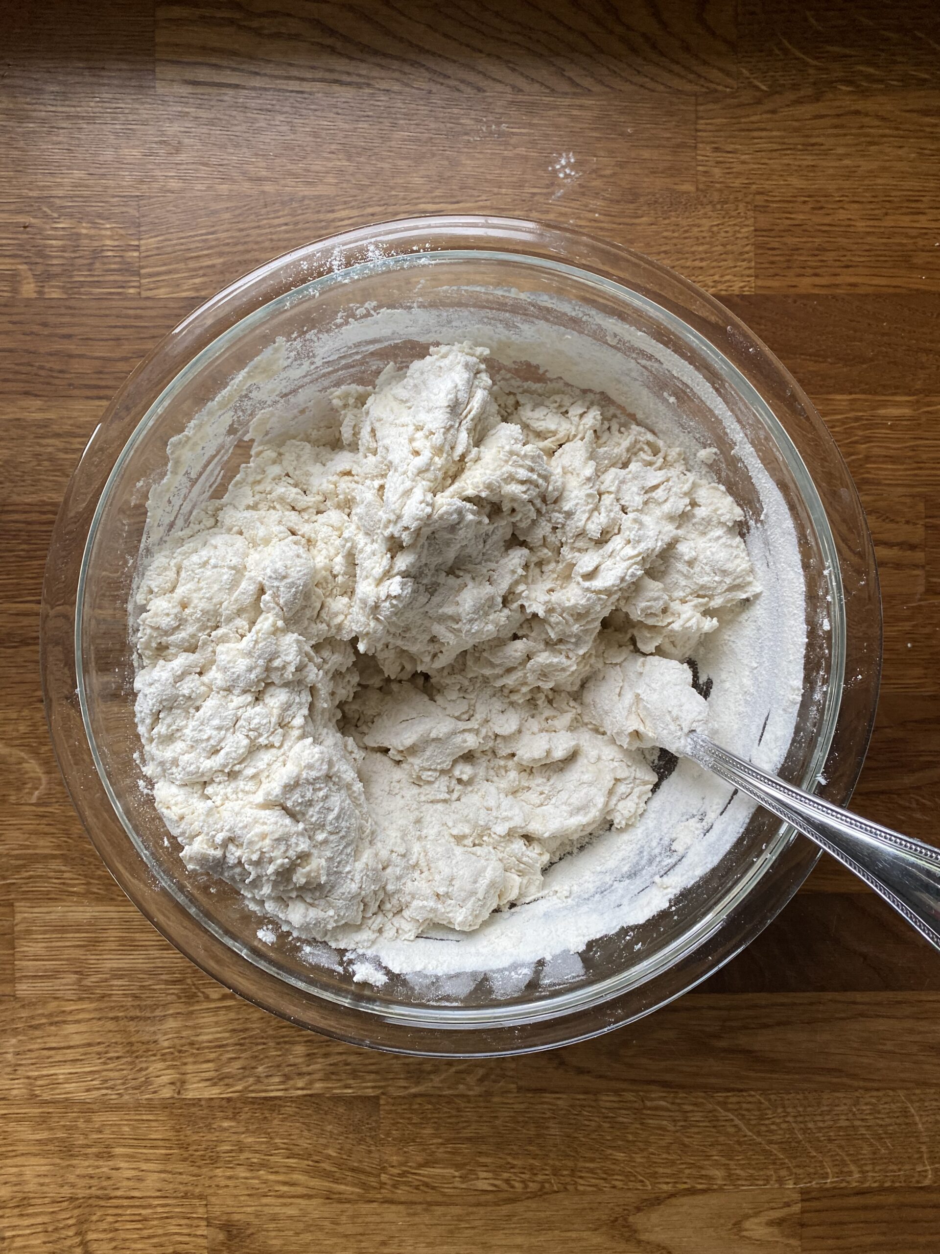 Adding wet ingredients and mixing to moisten the flour for sourdough flatbread dough.