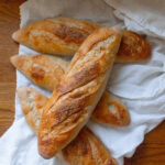 four freshly baked sourdough baguettes